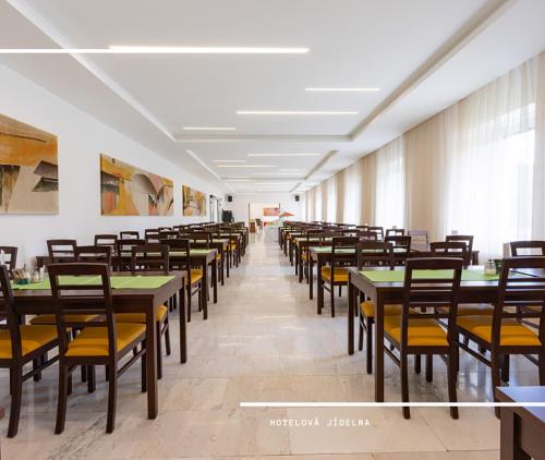 jadalnia ze stołami i krzesłami w obiekcie Hotel Kamzík *** w mieście Malá Morávka