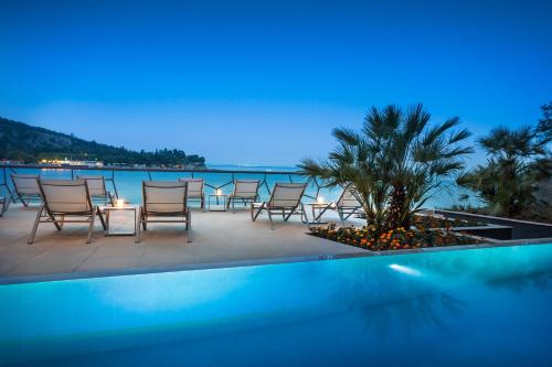a group of chairs and a table next to a swimming pool at Design Hotel Navis in Opatija