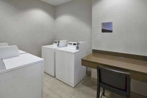 a laundry room with a washer and dryer and a table at Embassy Suites Columbus - Airport in Columbus