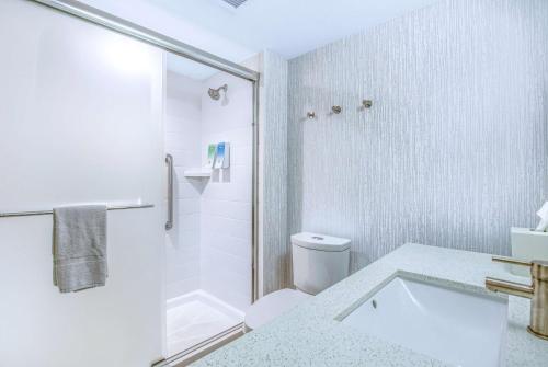 a white bathroom with a shower and a toilet at Home2 Suites by Hilton Mobile West I-10 Tillmans Corner in Tillmans Corner