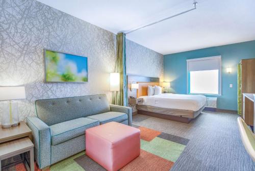 ティルマンズ・コーナーにあるHome2 Suites by Hilton Mobile West I-10 Tillmans Cornerのベッドとソファ付きのホテルルーム