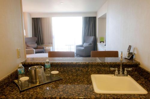 een badkamer met een wastafel en een kamer bij DoubleTree by Hilton Midland Plaza in Midland
