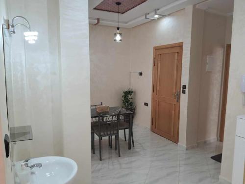 a bathroom with a table and a dining room with a sink at Appartement Dar Meknès in Meknès