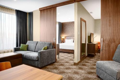 um quarto de hotel com um sofá e uma cama em Hilton Montreal/Laval em Laval