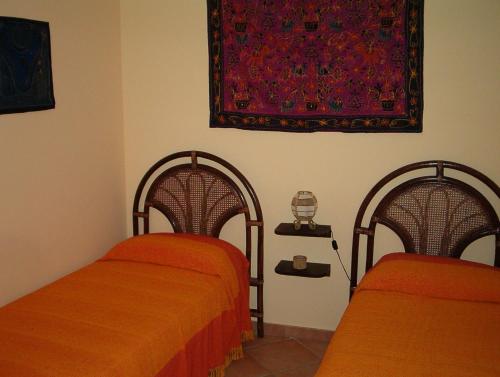 - 2 lits avec des draps orange dans une chambre dans l'établissement Saline, à Favignana