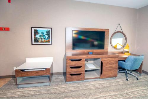 a desk with a television and a chair in a room at Hampton by Hilton Ottawa in Ottawa