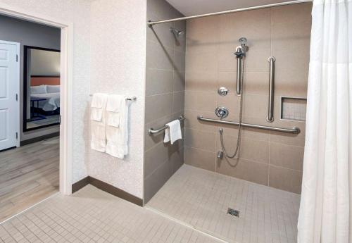ein Bad mit einer Dusche und weißen Handtüchern in der Unterkunft Hampton by Hilton Ottawa in Ottawa