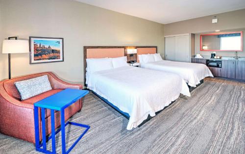 a hotel room with two beds and a couch at Hampton by Hilton Ottawa in Ottawa