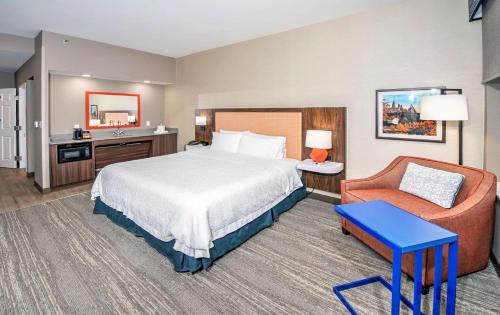 オタワにあるHampton by Hilton Ottawaのベッドと椅子付きのホテルルーム