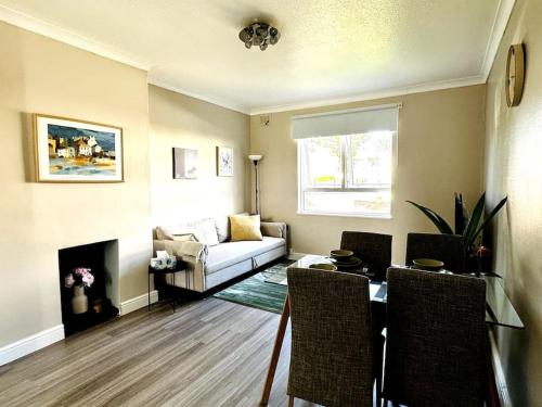 a living room with a couch and a table and chairs at Cosy bright home in Murrayfield in Edinburgh