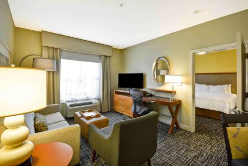 a hotel room with a bed and a desk at Homewood Suites Dallas-Frisco in Frisco