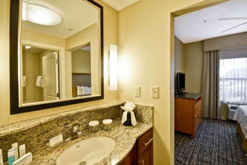 a bathroom with a sink and a large mirror at Homewood Suites Dallas-Frisco in Frisco