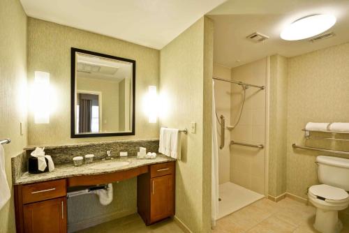 a bathroom with a sink and a toilet and a mirror at Homewood Suites Dallas-Frisco in Frisco