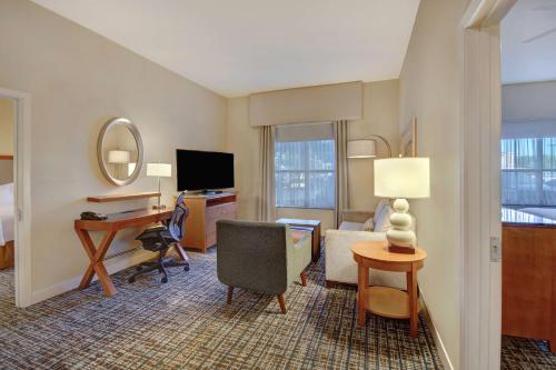 a hotel room with a bed and a desk with a computer at Homewood Suites Dallas-Frisco in Frisco