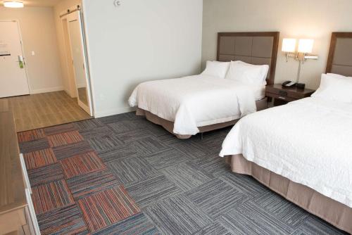 a hotel room with two beds and a bathroom at Hampton Inn & Suites Bay City in Bay City