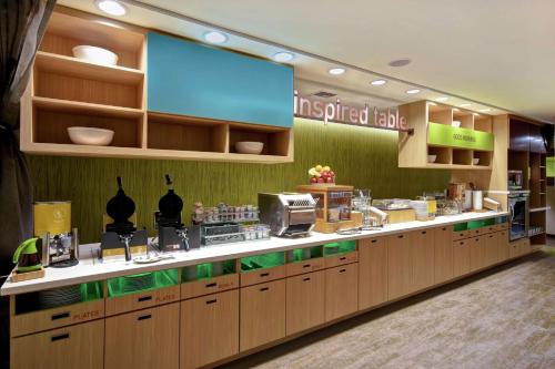 a restaurant with a counter with aasteryasteryasteryasteryasteryasteryasteryasteryastery at Home2 Suites by Hilton Harvey New Orleans Westbank in Harvey