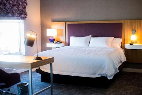 a hotel room with a bed and a desk and a bed sidx sidx sidx at Hampton Inn & Suites Warrington Horsham in Warrington