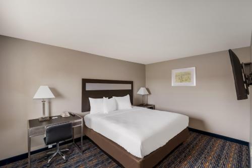 a hotel room with a bed and a desk with a computer at Americas Best Value Inn Farmington in Farmington