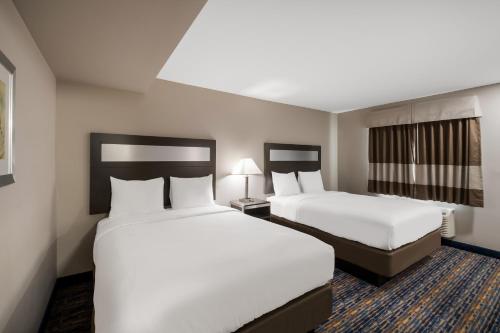 a hotel room with two beds and a window at Americas Best Value Inn Farmington in Farmington