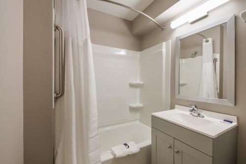 a bathroom with a sink and a shower with a mirror at Americas Best Value Inn Farmington in Farmington