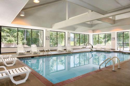 una gran piscina con sillas y ventanas en Homewood Suites Williamsburg en Williamsburg