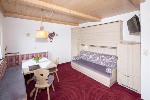 a bedroom with a bed and a desk and a table at Landhaus Greil in Reith im Alpbachtal