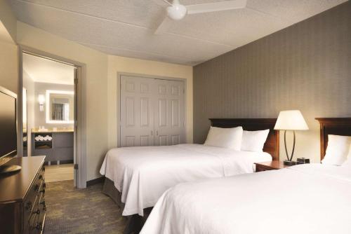 a hotel room with two beds and a television at Homewood Suites Williamsburg in Williamsburg