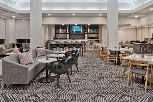a lobby with tables and chairs and a bar at Hilton Garden Inn Birmingham SE/Liberty Park in Birmingham