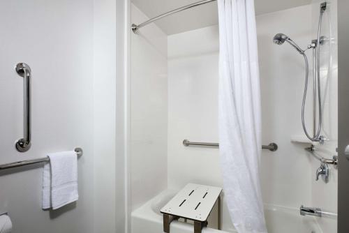 a white bathroom with a shower and a toilet at Hampton Inn Niagara Falls in Niagara Falls