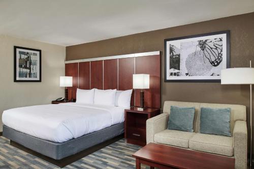 a hotel room with a bed and a chair at Doubletree By Hilton Raleigh Crabtree Valley in Raleigh