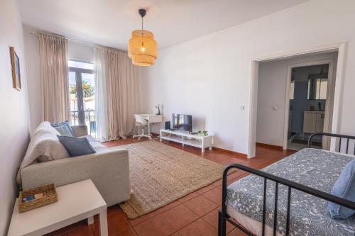 a living room with a couch and a bed at SandyBeachApartment in Porto Santo