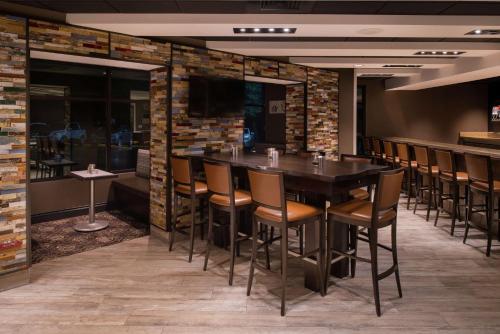 a bar in a restaurant with a table and chairs at Doubletree By Hilton Raleigh Crabtree Valley in Raleigh