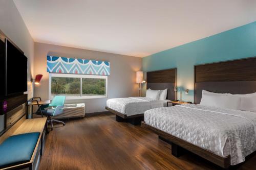 a hotel room with two beds and a flat screen tv at Tru By Hilton Radford in Christiansburg