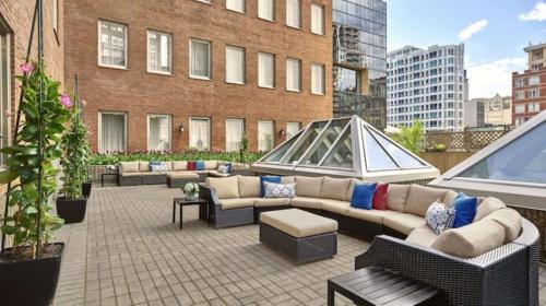 a patio with couches and tables on a building at Vogue Hotel Montreal Downtown, Curio Collection by Hilton in Montreal