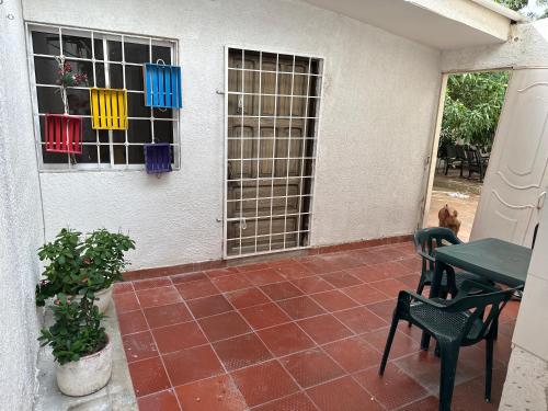 a patio with a table and chairs and a window at Casa de LuCa apartamento familiar in Santa Marta