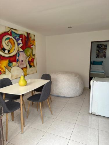 a table and chairs in a room with a painting at Casa de LuCa apartamento familiar in Santa Marta
