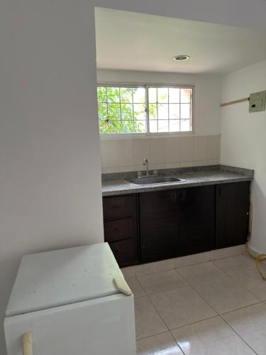 an empty kitchen with a sink and a window at Casa de LuCa apartamento familiar in Santa Marta