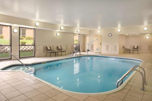 una gran piscina en un hotel con mesas y sillas en Hampton Inn Mansfield/Ontario, en Mansfield