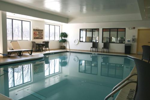 a swimming pool with chairs and tables in a building at Hampton Inn Turnersville in Blackwood