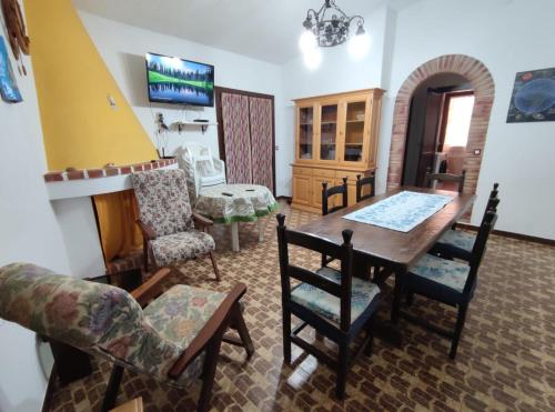 ein Wohnzimmer mit einem Esstisch und Stühlen in der Unterkunft Sagittario House in Torre delle Stelle
