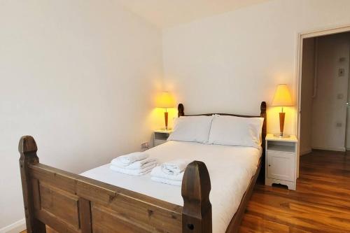 a bedroom with a bed with two lamps on two tables at Cozy flat near Kings Cross in London
