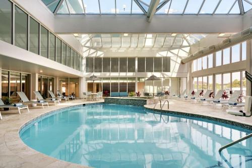 a large swimming pool in a building with chairs at DoubleTree by Hilton Ocean City Oceanfront in Ocean City