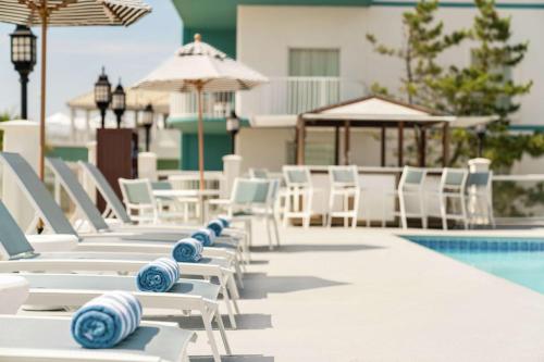 a row of lounge chairs next to a swimming pool at DoubleTree by Hilton Ocean City Oceanfront in Ocean City