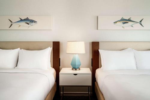 a hotel room with two beds and a lamp on a night stand at DoubleTree by Hilton Ocean City Oceanfront in Ocean City