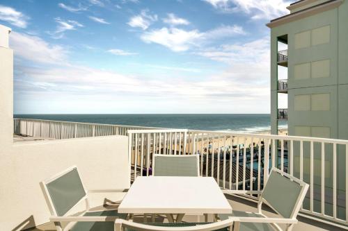 a balcony with a table and chairs and the ocean at DoubleTree by Hilton Ocean City Oceanfront in Ocean City