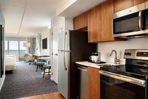 a kitchen with a refrigerator and a living room at DoubleTree by Hilton Ocean City Oceanfront in Ocean City
