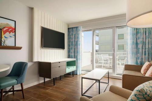 a living room with a couch and a tv at DoubleTree by Hilton Ocean City Oceanfront in Ocean City