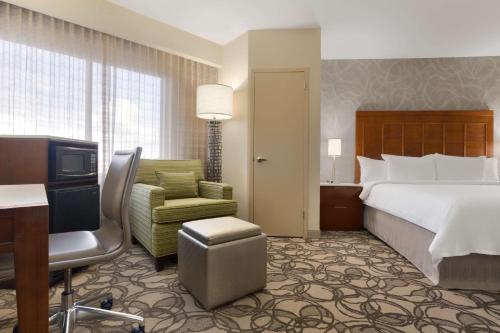 a hotel room with a bed and a chair at Embassy Suites San Antonio Airport in San Antonio