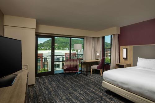 アッシュビルにあるHilton Asheville Biltmore Parkのベッドと机があるホテルの部屋