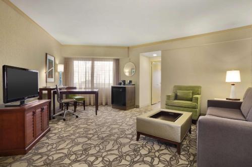 a living room with a television and a couch and a table at Embassy Suites San Antonio Airport in San Antonio